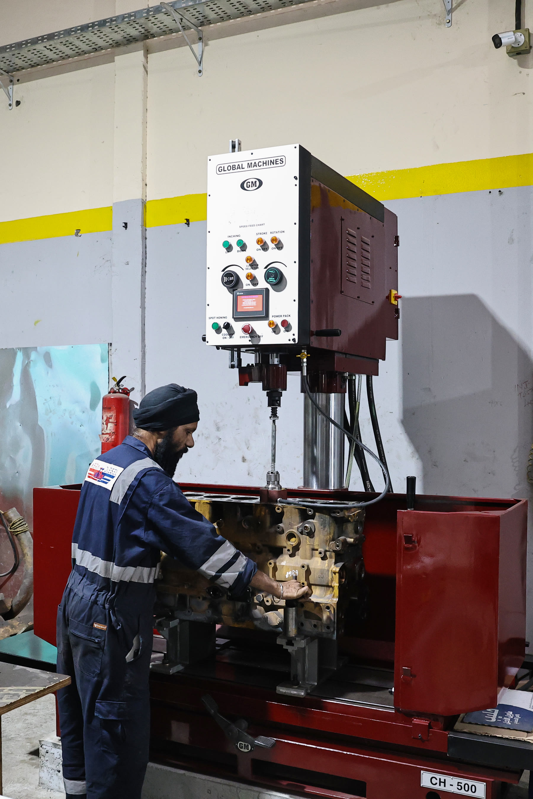 Technician working at the vertical boring machine with an engine block