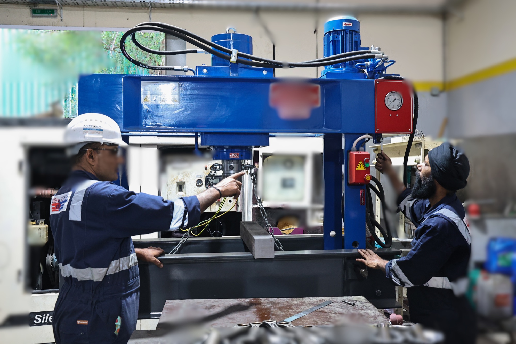 Technicians working at a large workshop machine with the component fixtured