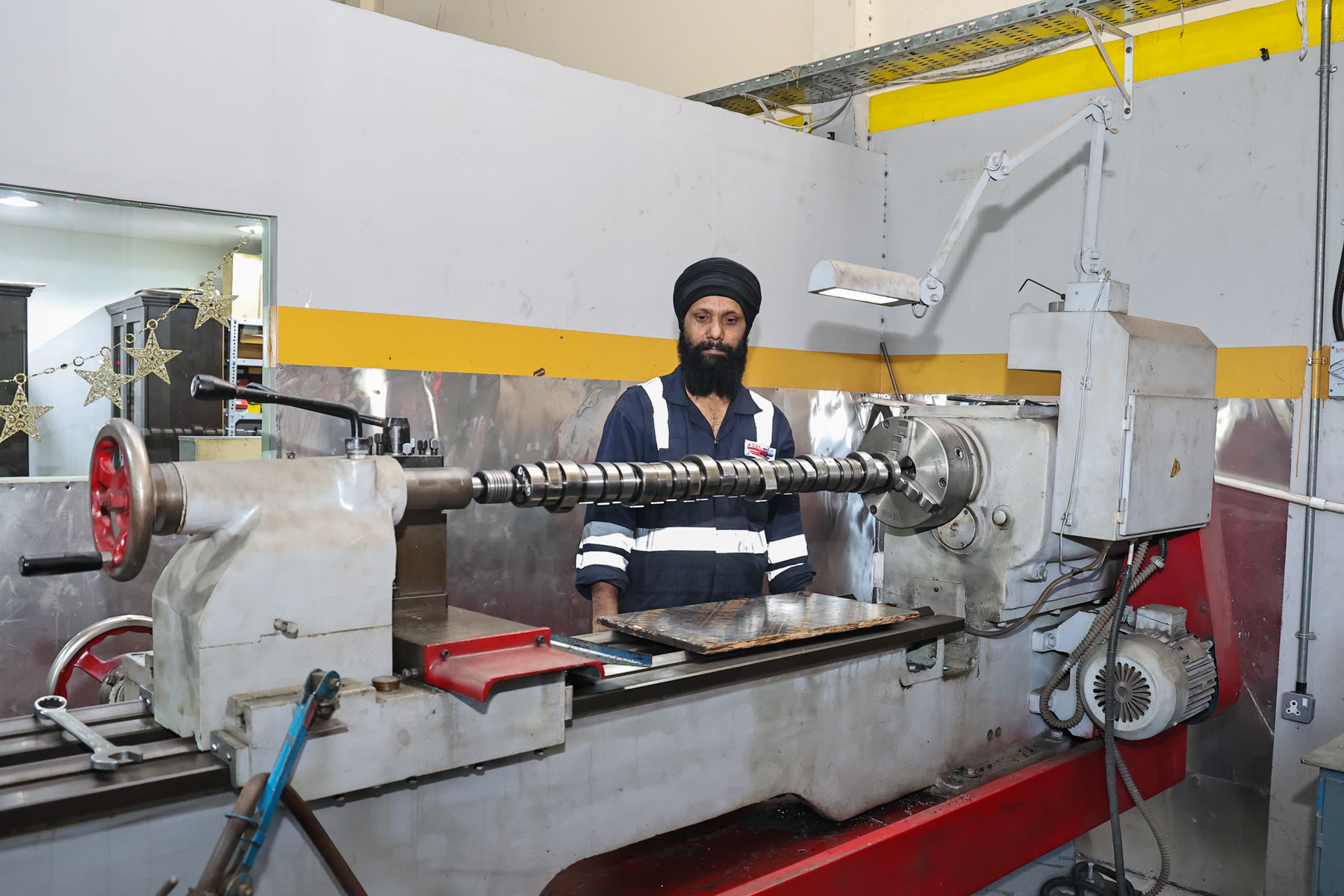 Machinist setting up a diesel engine shaft in the grinder at Abra Diesel