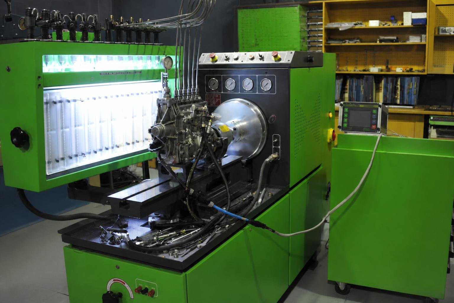 Bright green Bosch diesel-pump calibration bench with illuminated flow tubes, mounted pump, gauges, hoses, and computer controls.
