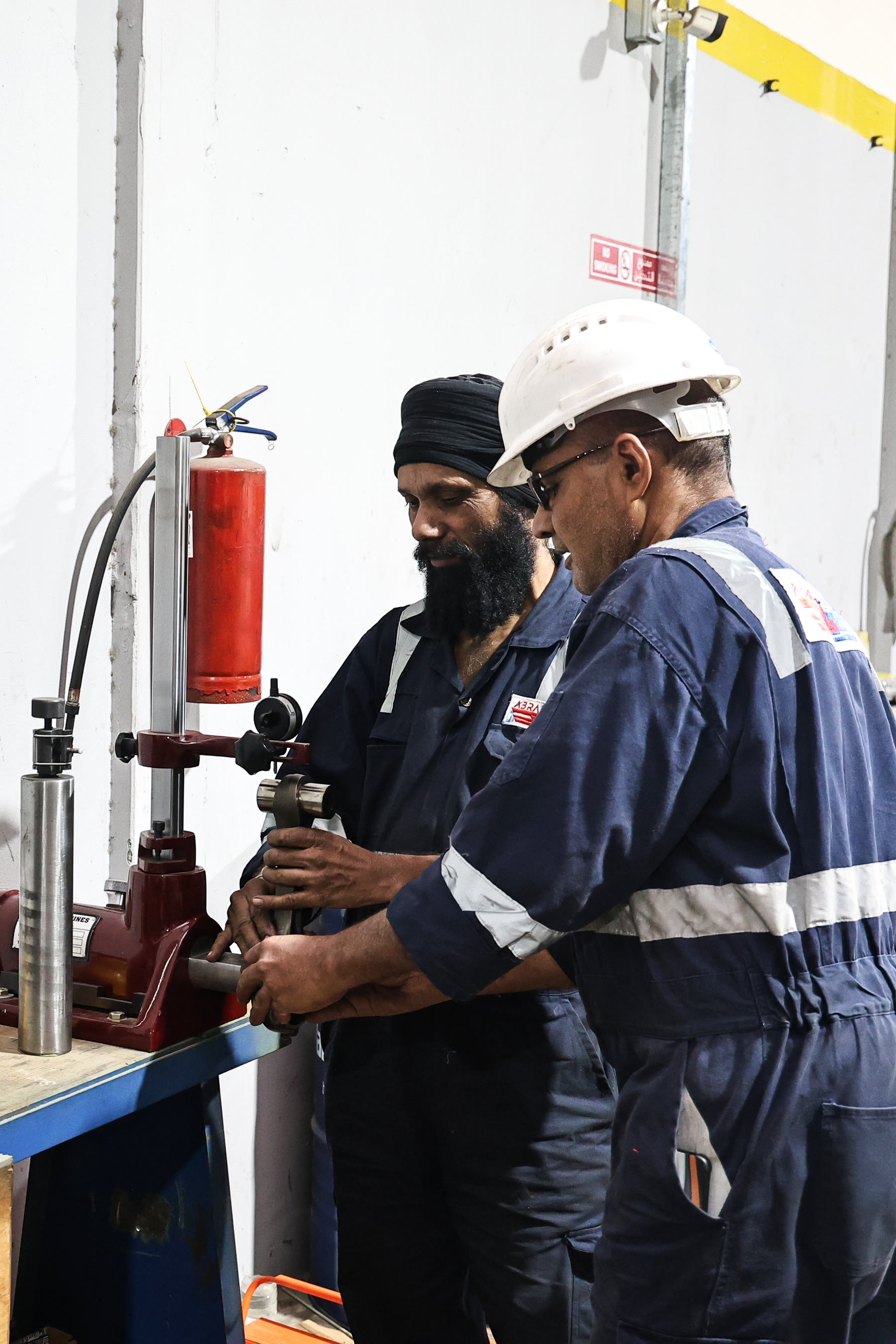 two Abra Diesel technicians working at a precision test bench