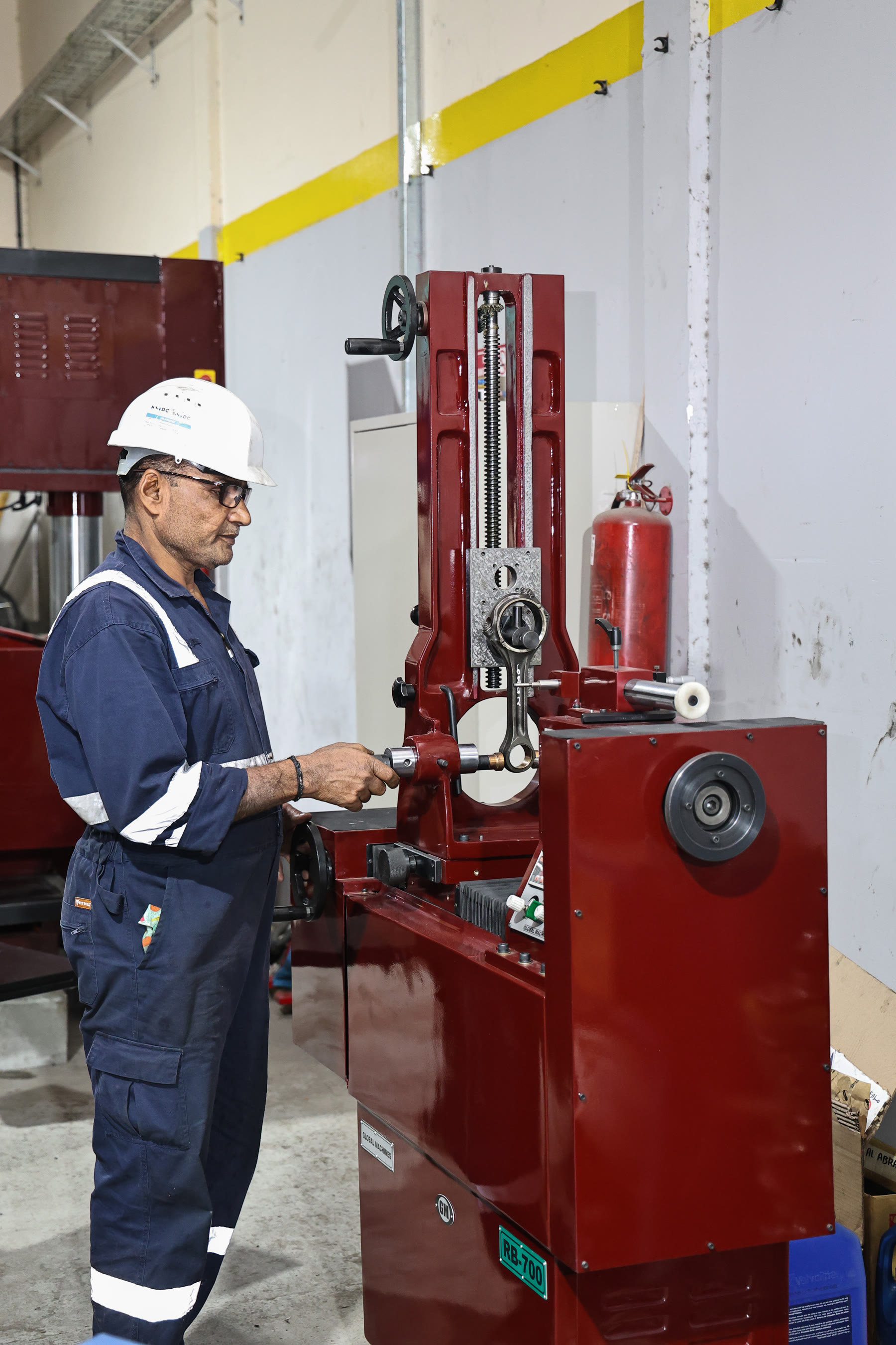 technician operating red RB-700 conrod boring machine