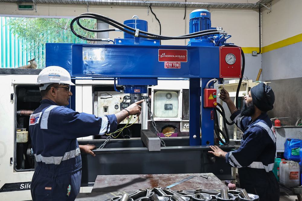 Abra Diesel technicians working on a hydraulic press in the Sharjah workshop